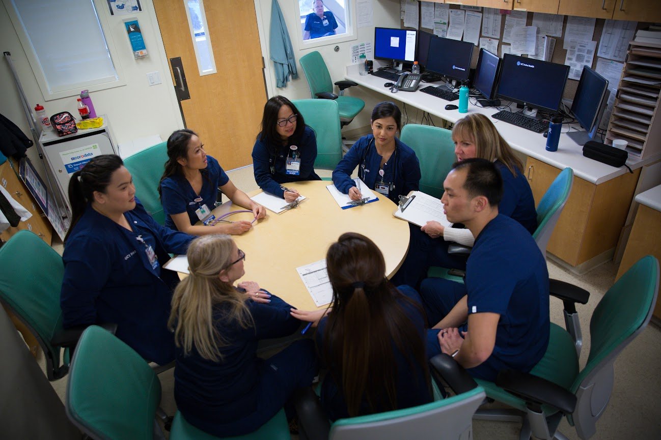 A group of nurses ideate nurse retention strategies while seated at a table